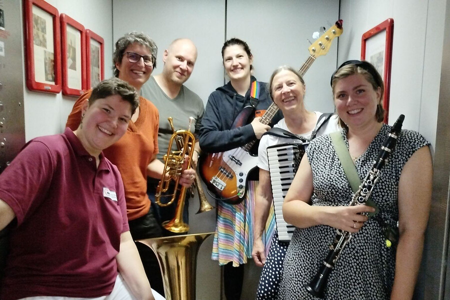 Musikant:innen im Aufzug lachen in die Kamera