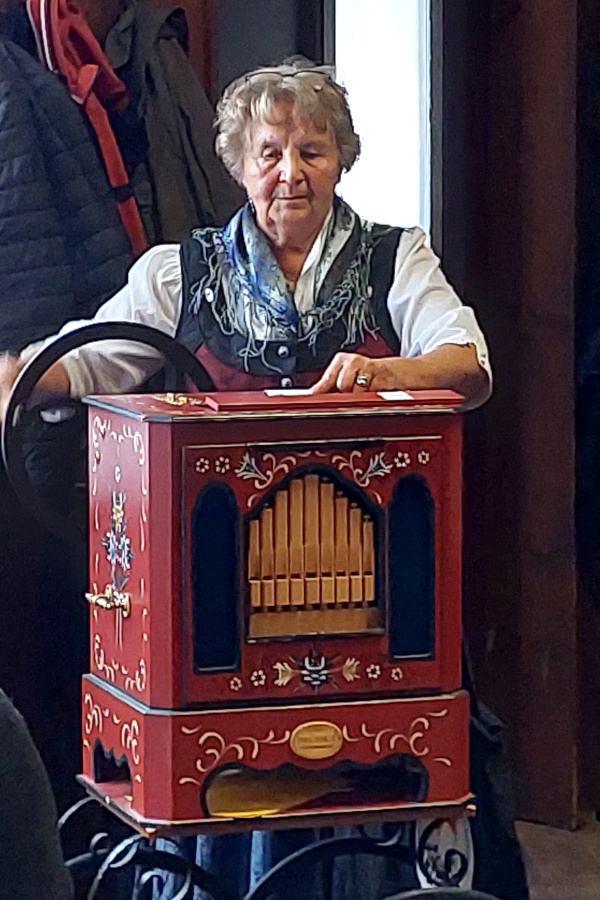 Eine Frau hinter einer Drehorgel