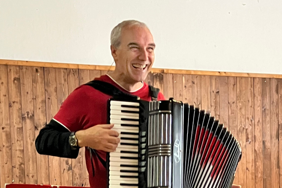 Sven Bach grinsender Mann mit Akkordeon