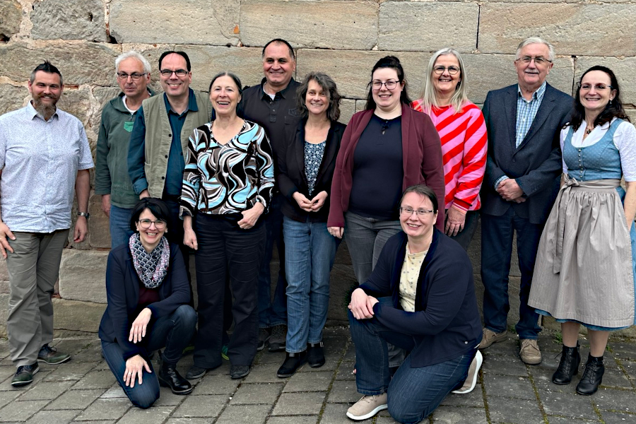 Eine Gruppe von Menschen vor einer Sandsteinmauer